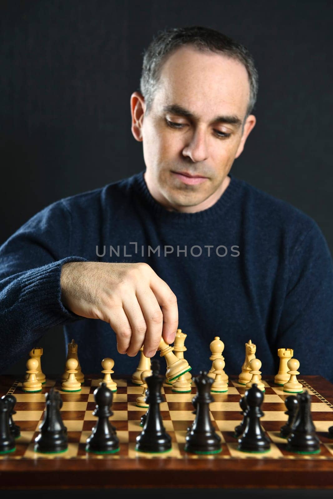 Man moving a chess piece on wooden chessboard