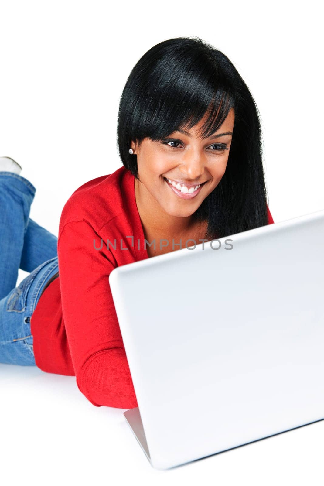 Smiling black woman typing on computer laying on floor