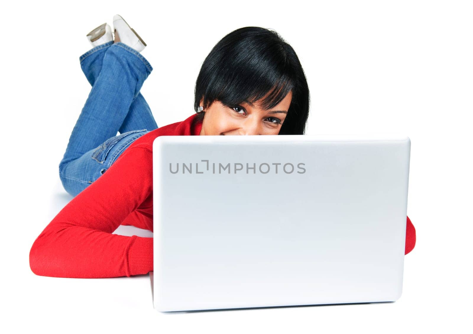 Smiling black woman peeking from behind computer laying on floor