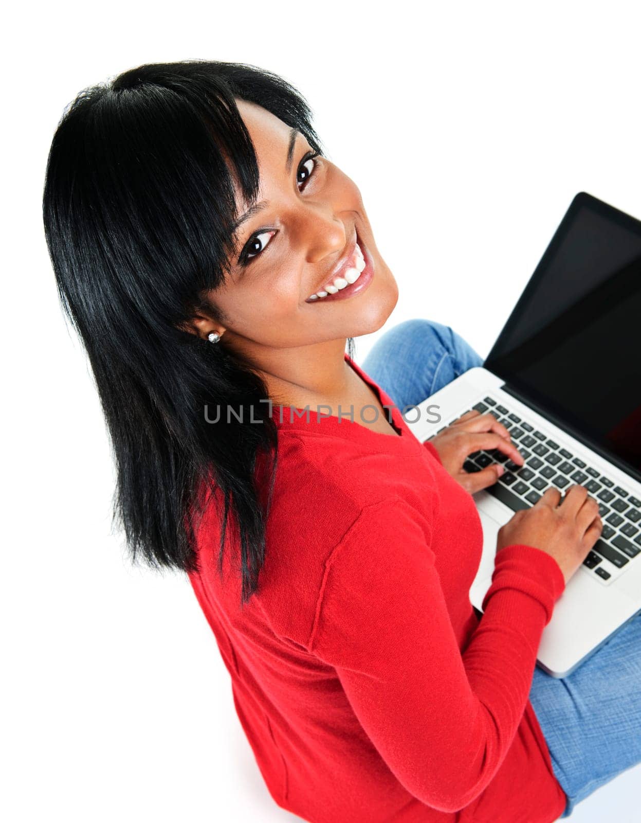 Smiling black woman looking up and typing on computer
