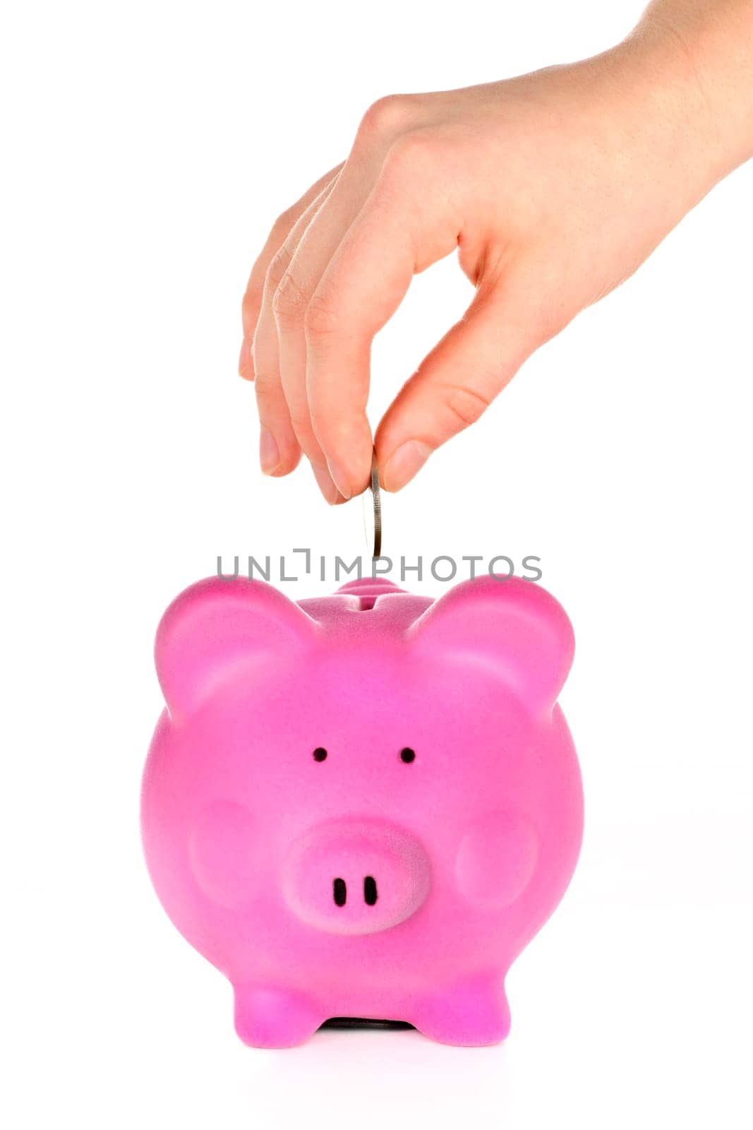 Hand putting coin into pink piggy bank slot