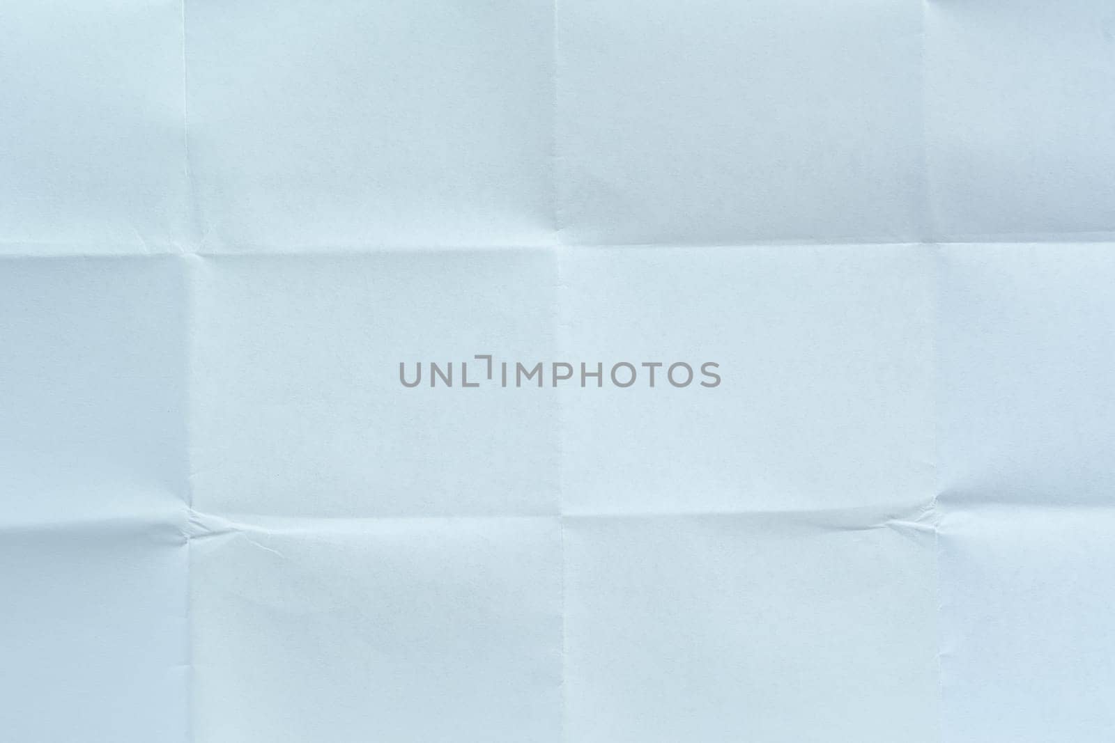 White paper sheet with visible folds and creases, creating a symmetrical textured background suitable for design, mockups, or artistic projects.