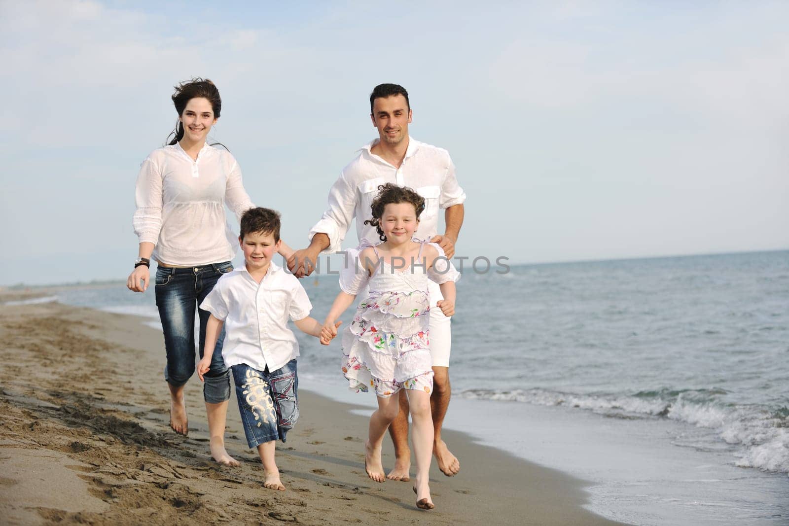 happy young family have fun and live healthy lifestyle on beach