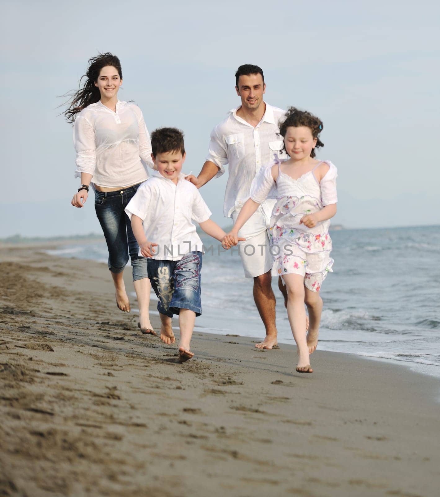 happy young family have fun and live healthy lifestyle on beach