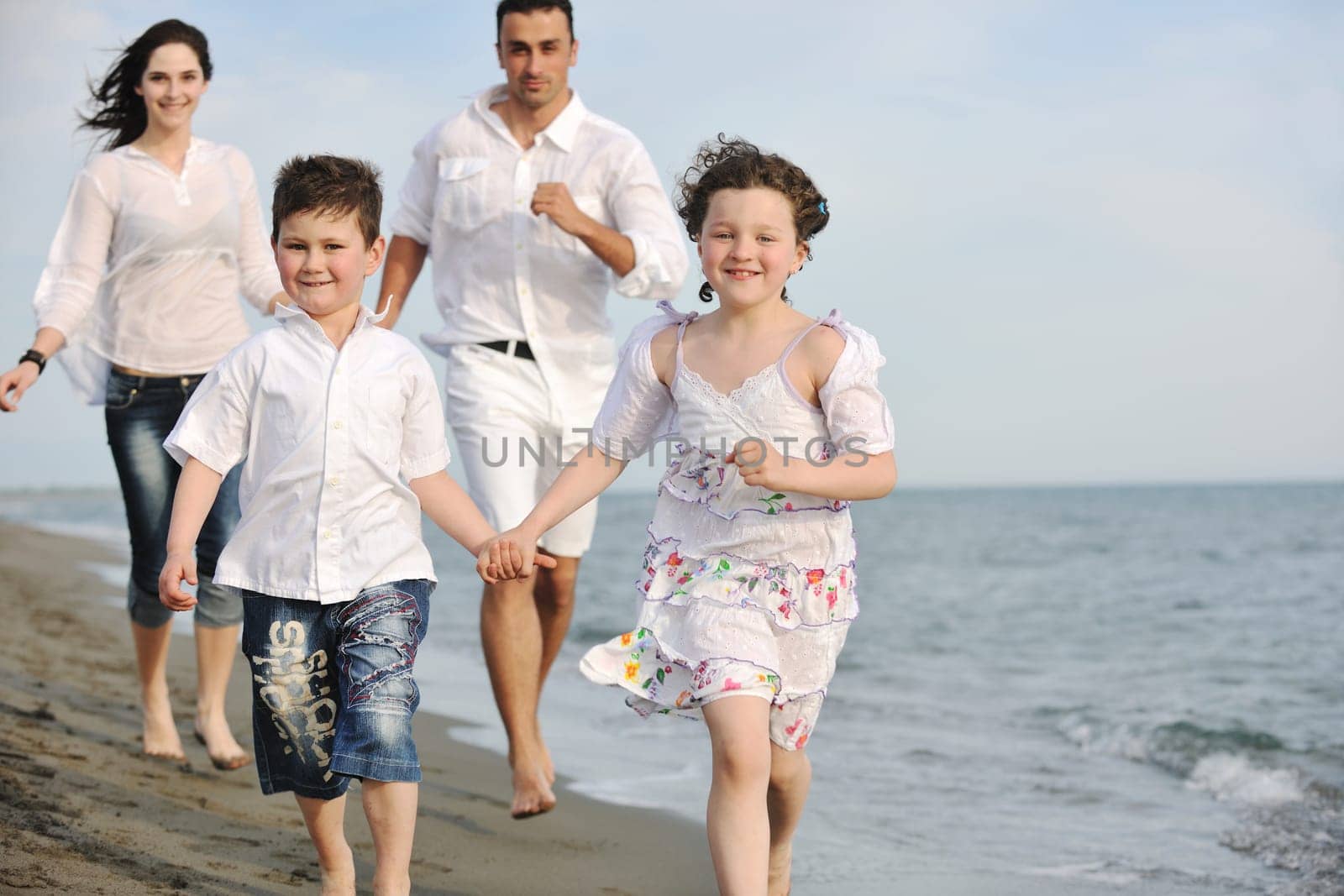happy young family have fun and live healthy lifestyle on beach
