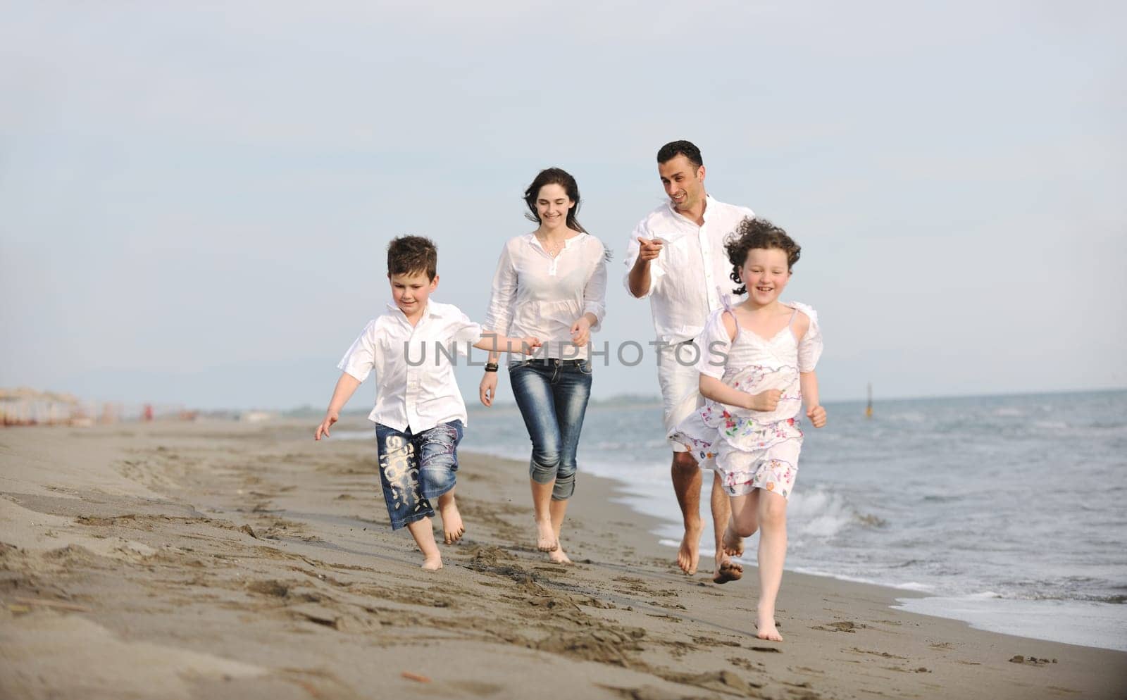 happy young family have fun and live healthy lifestyle on beach
