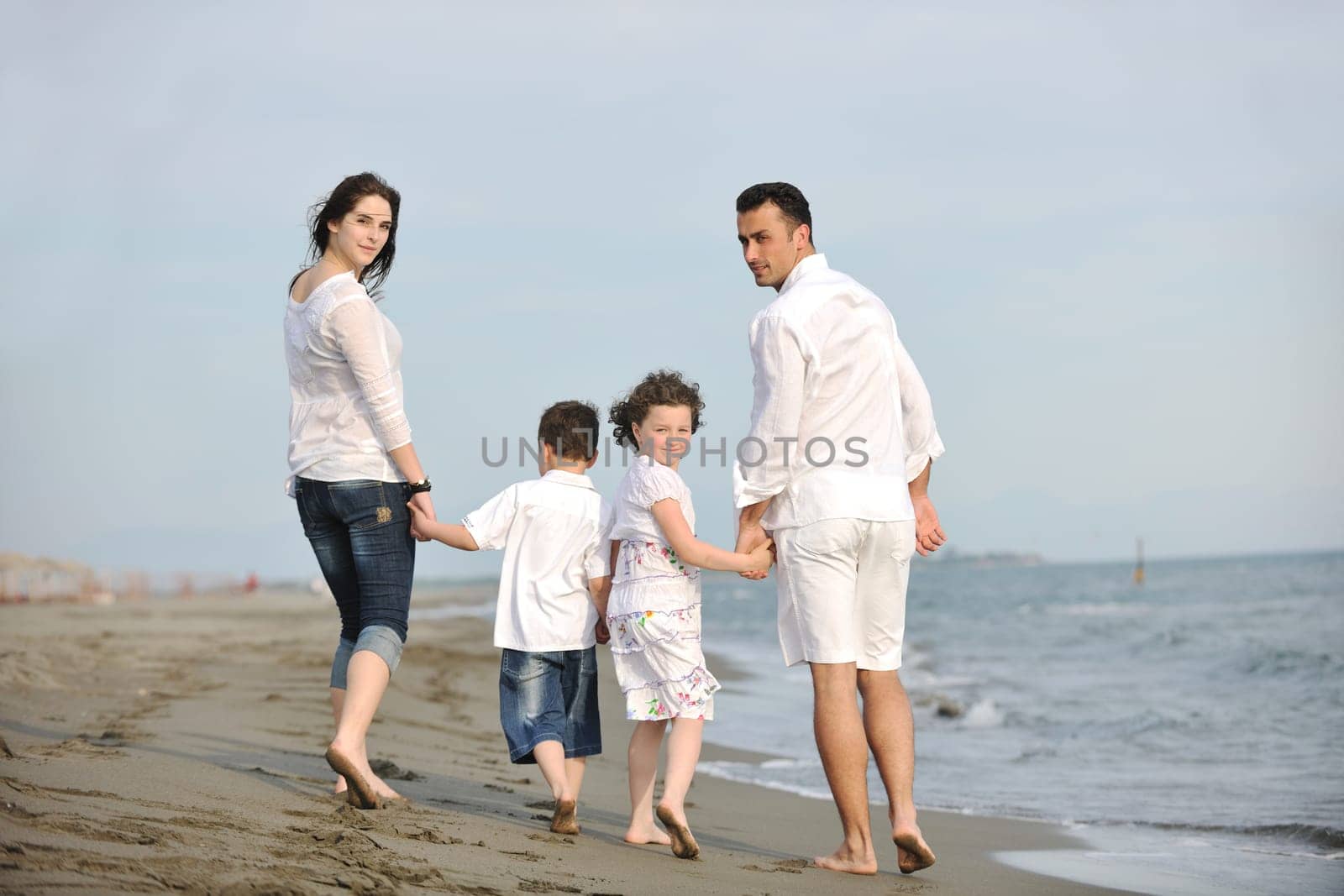 happy young family have fun and live healthy lifestyle on beach