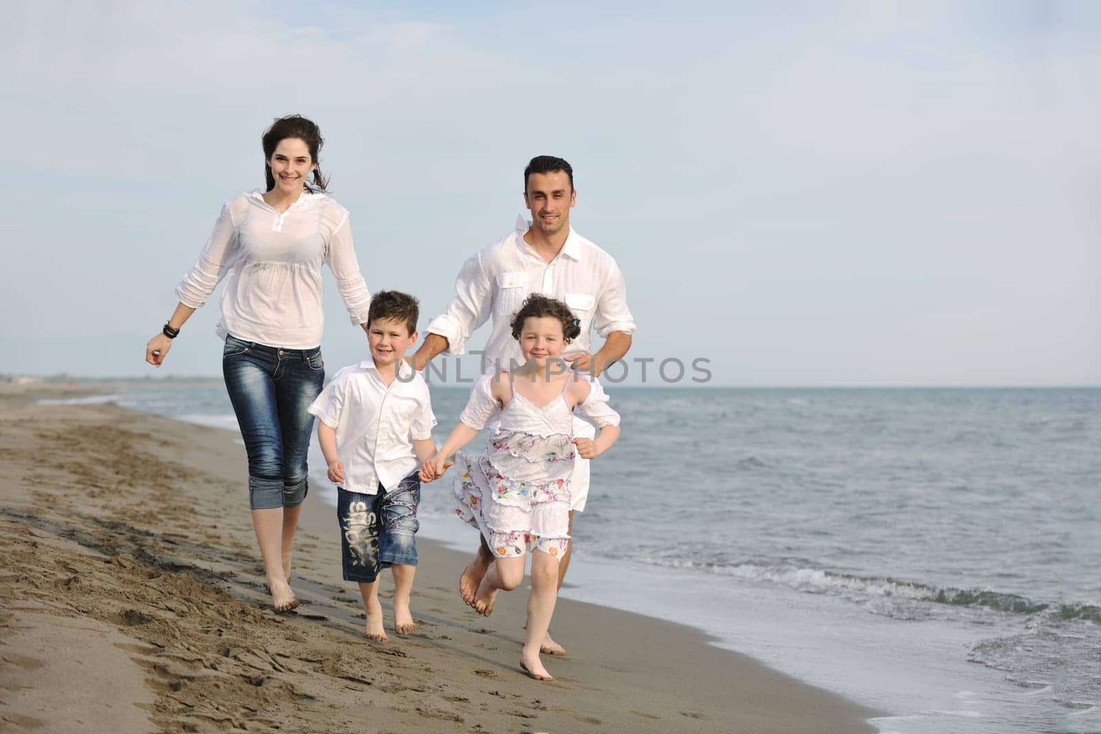 happy young family have fun and live healthy lifestyle on beach