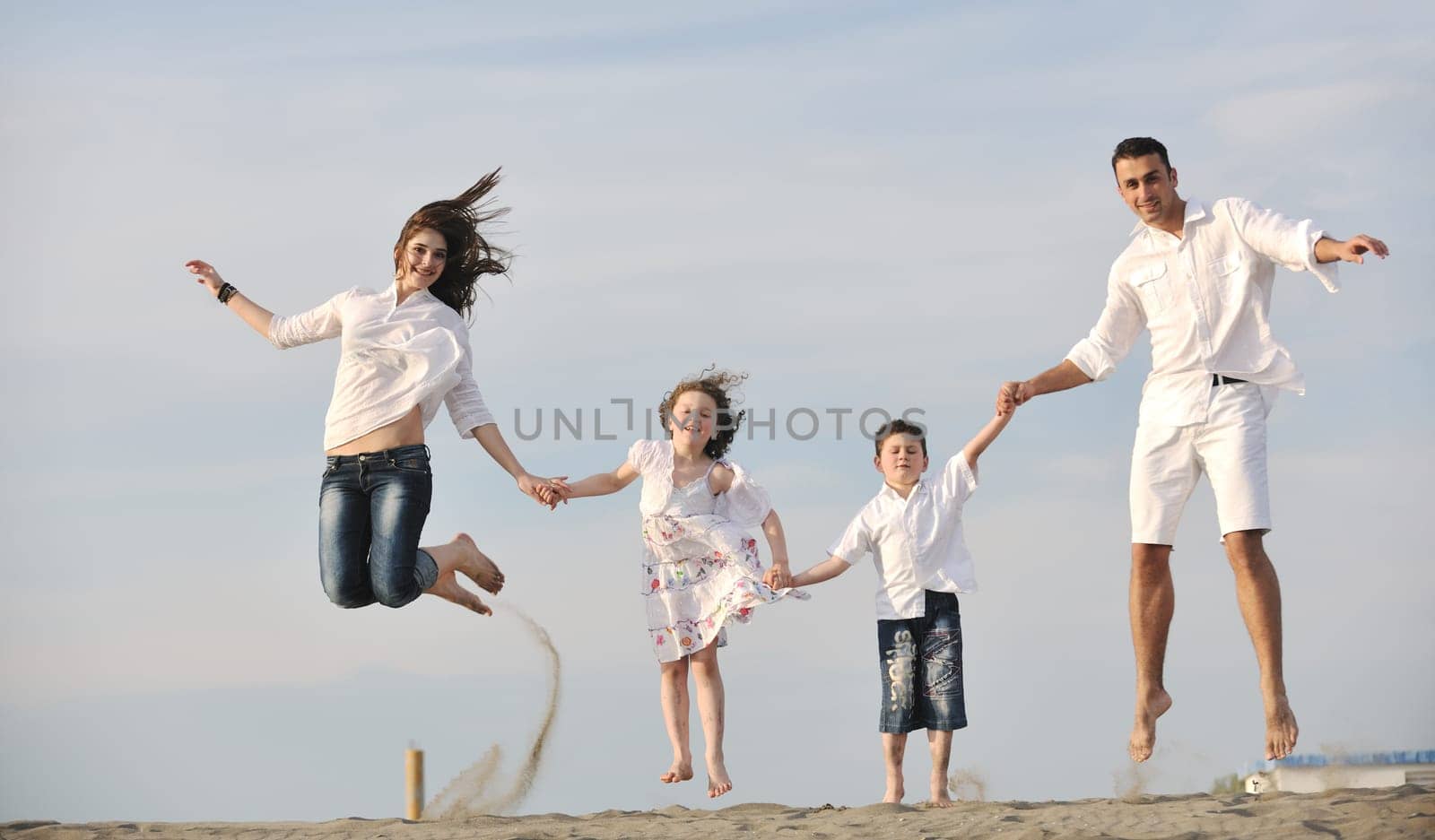 happy young family have fun and live healthy lifestyle on beach