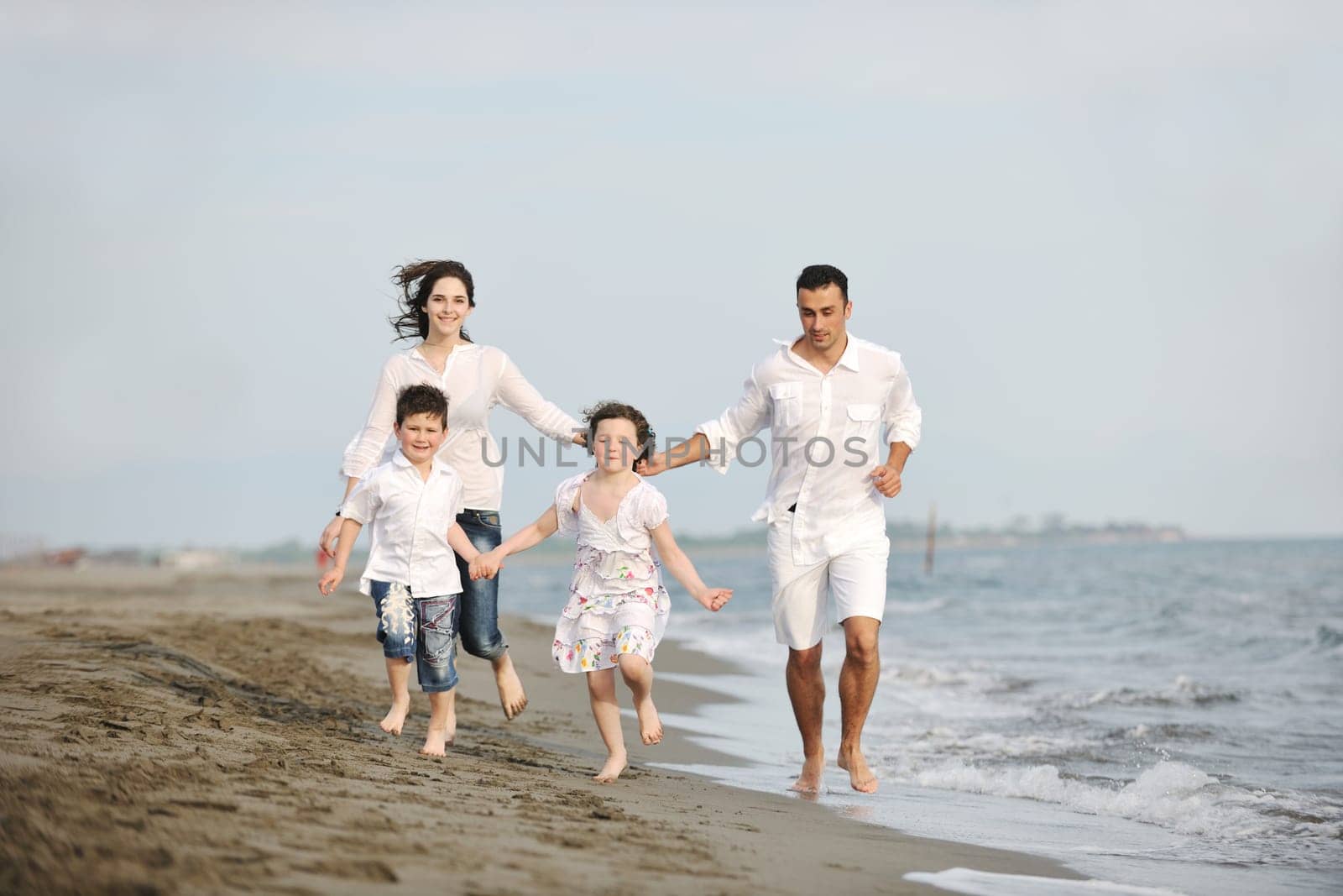 happy young family have fun and live healthy lifestyle on beach