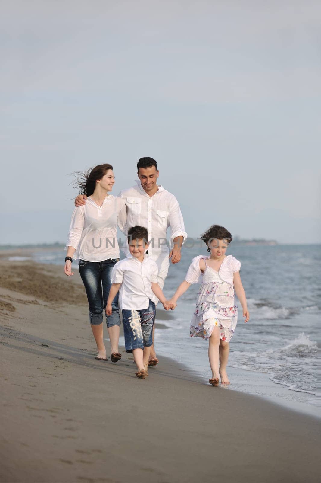 happy young family have fun and live healthy lifestyle on beach