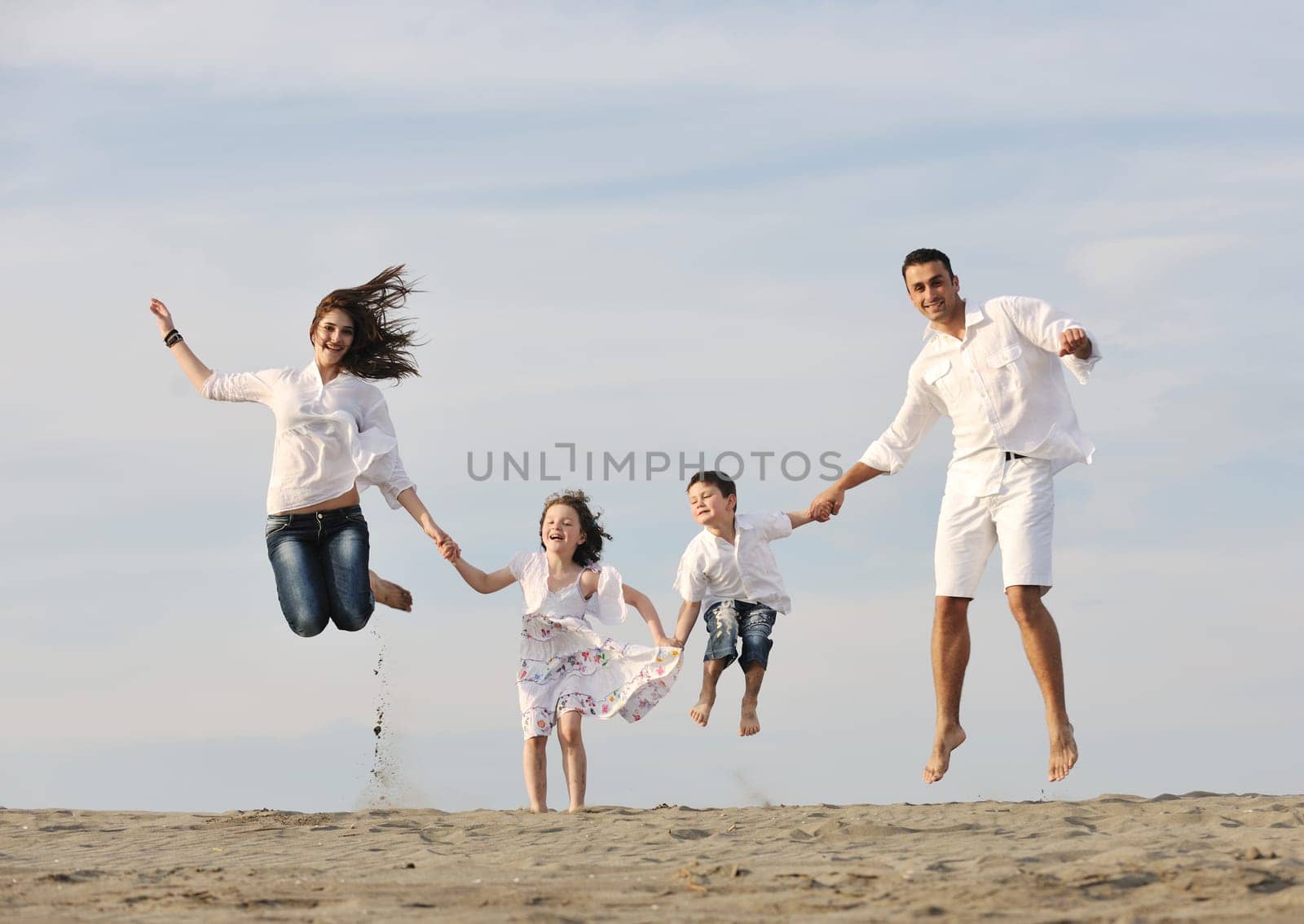 happy young family have fun and live healthy lifestyle on beach