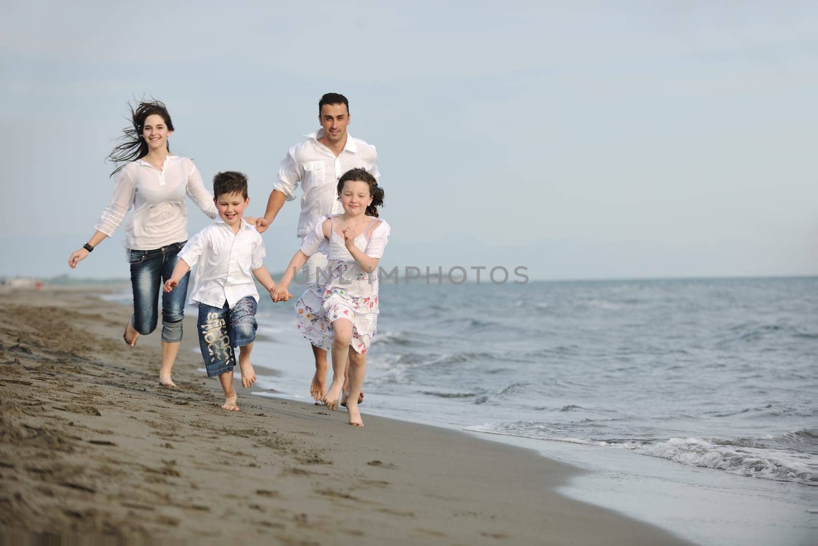 happy young family have fun and live healthy lifestyle on beach