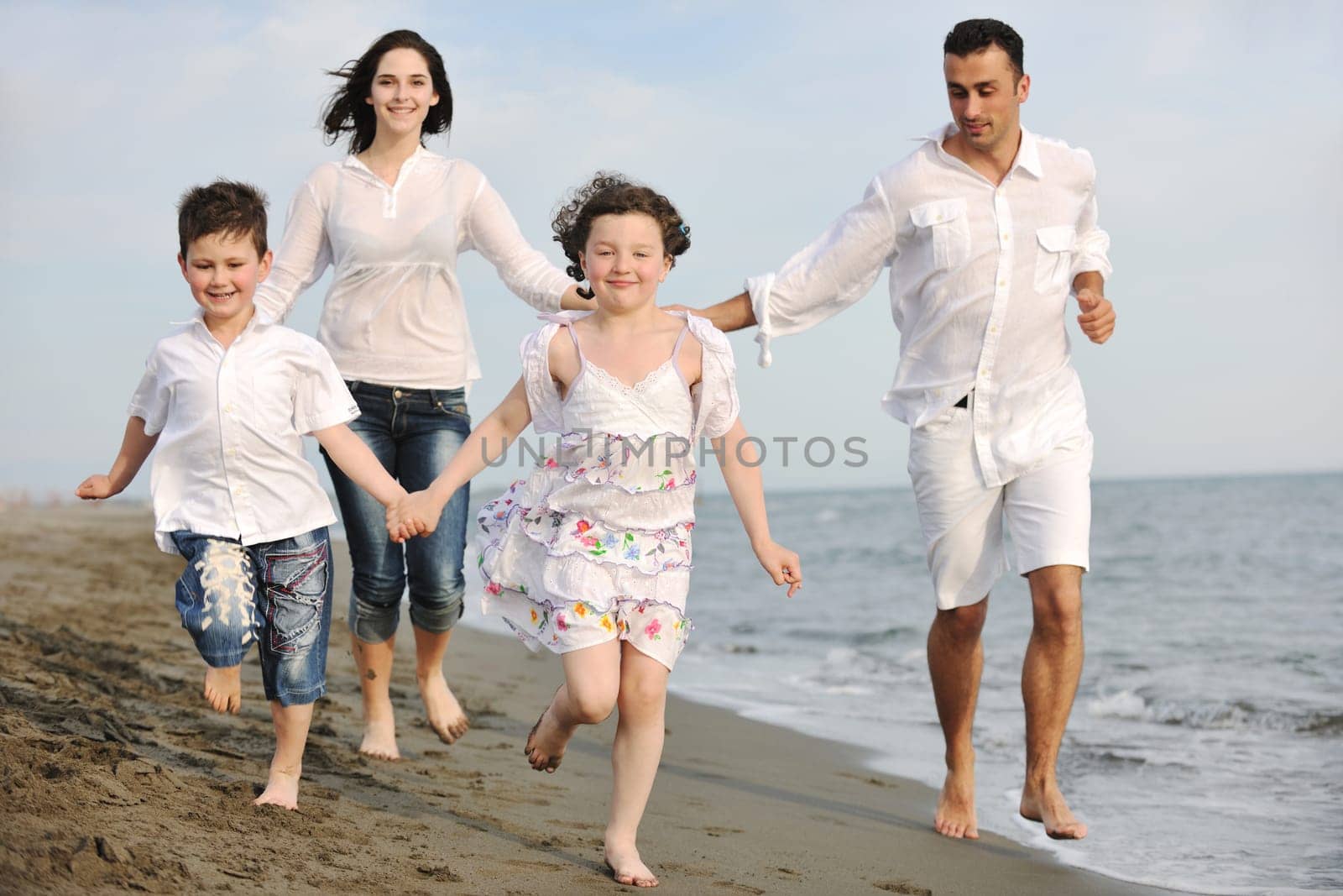 happy young family have fun and live healthy lifestyle on beach