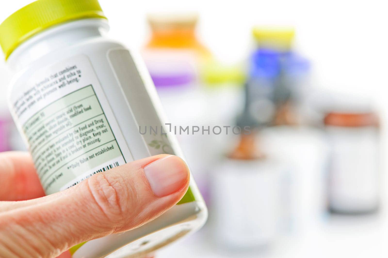 Hand holding medicine bottle to read label