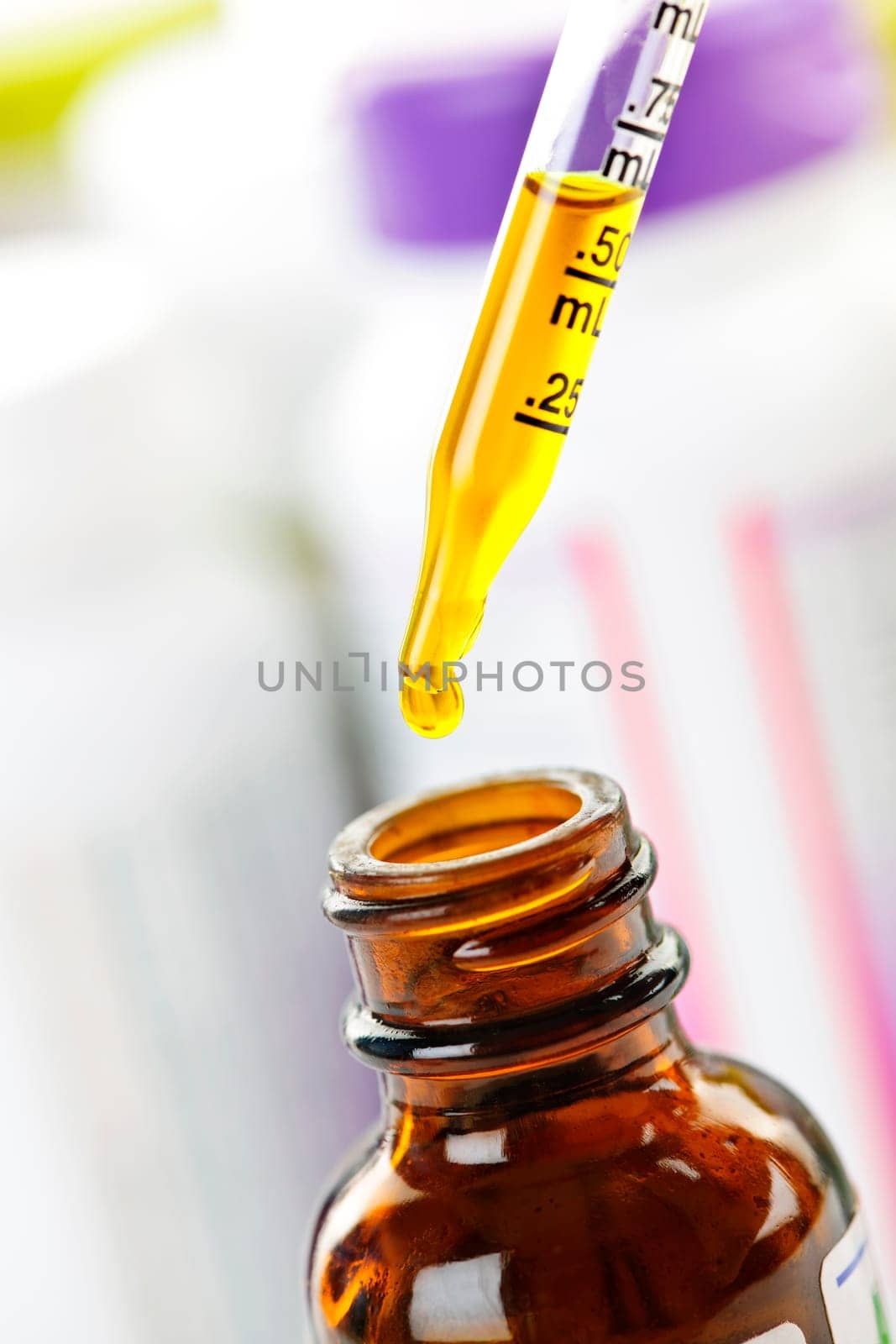Closeup of liquid medicine in glass dropper and bottle