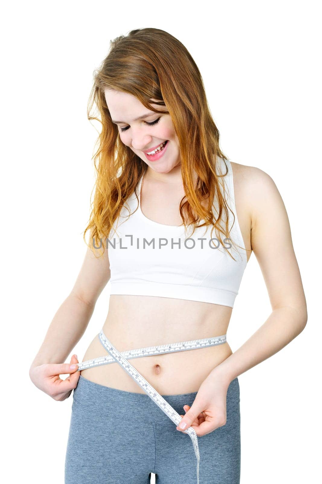 Happy fit young woman measuring waist with tape isolated on white