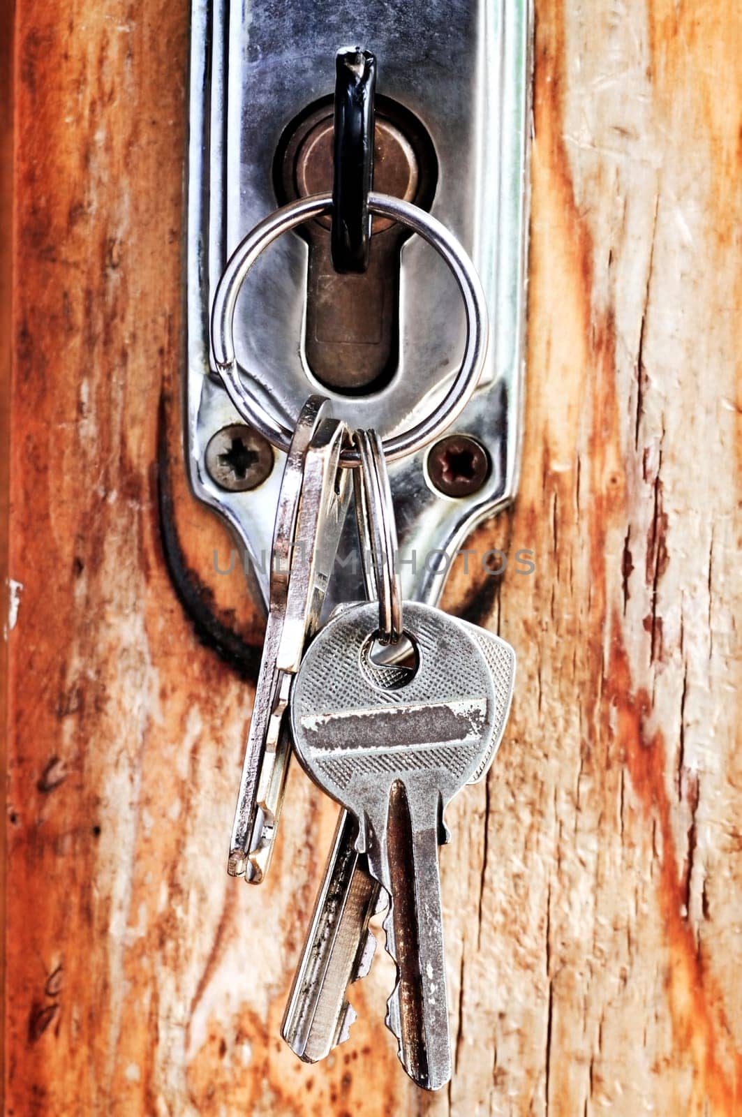 Set of keys in lock of old wooden door