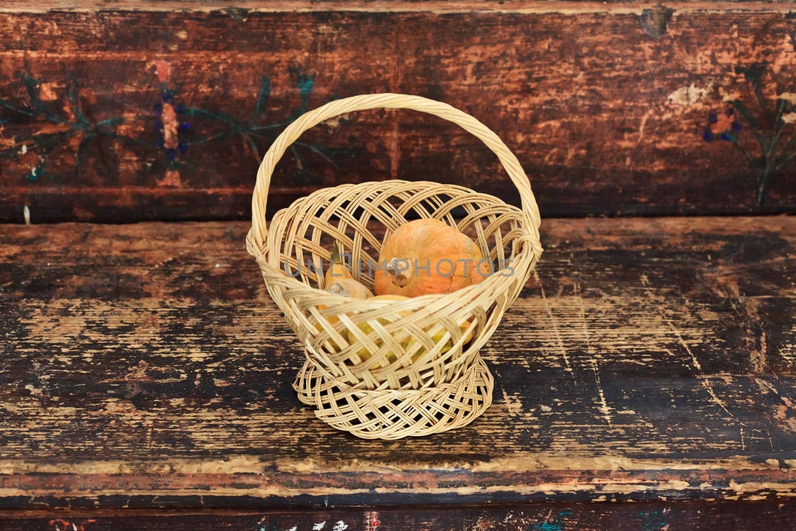 basket of autumn with pumpkins on the old sofa