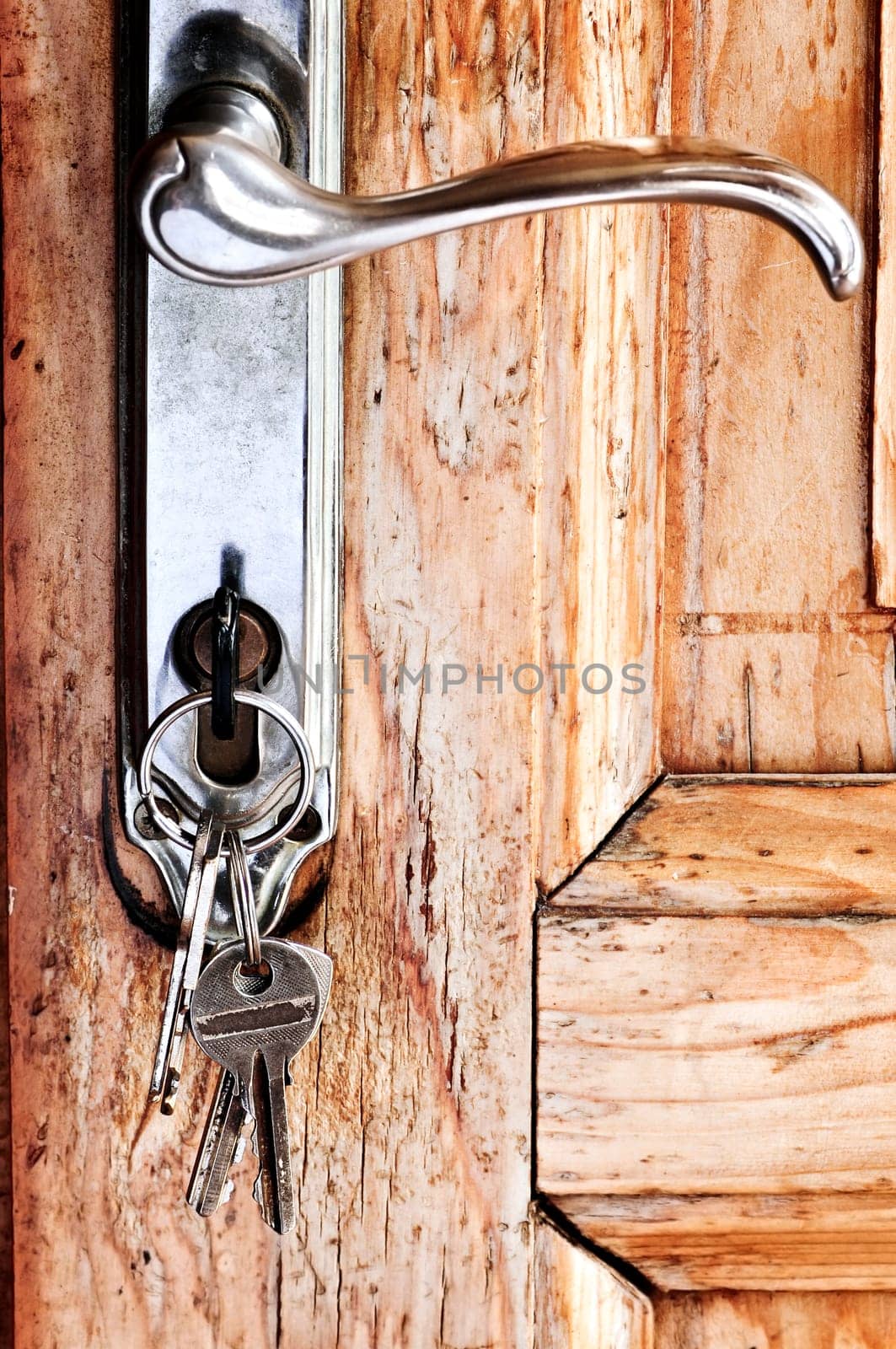 Set of keys in lock of old wooden door
