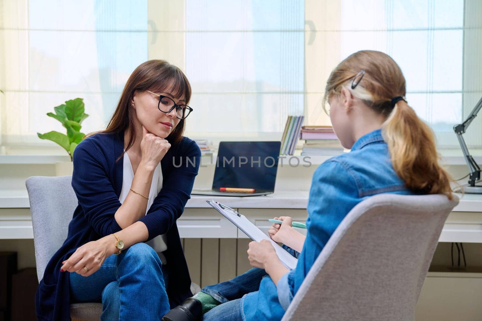 Pre-teen girl at therapy meeting with psychologist by VH-studio