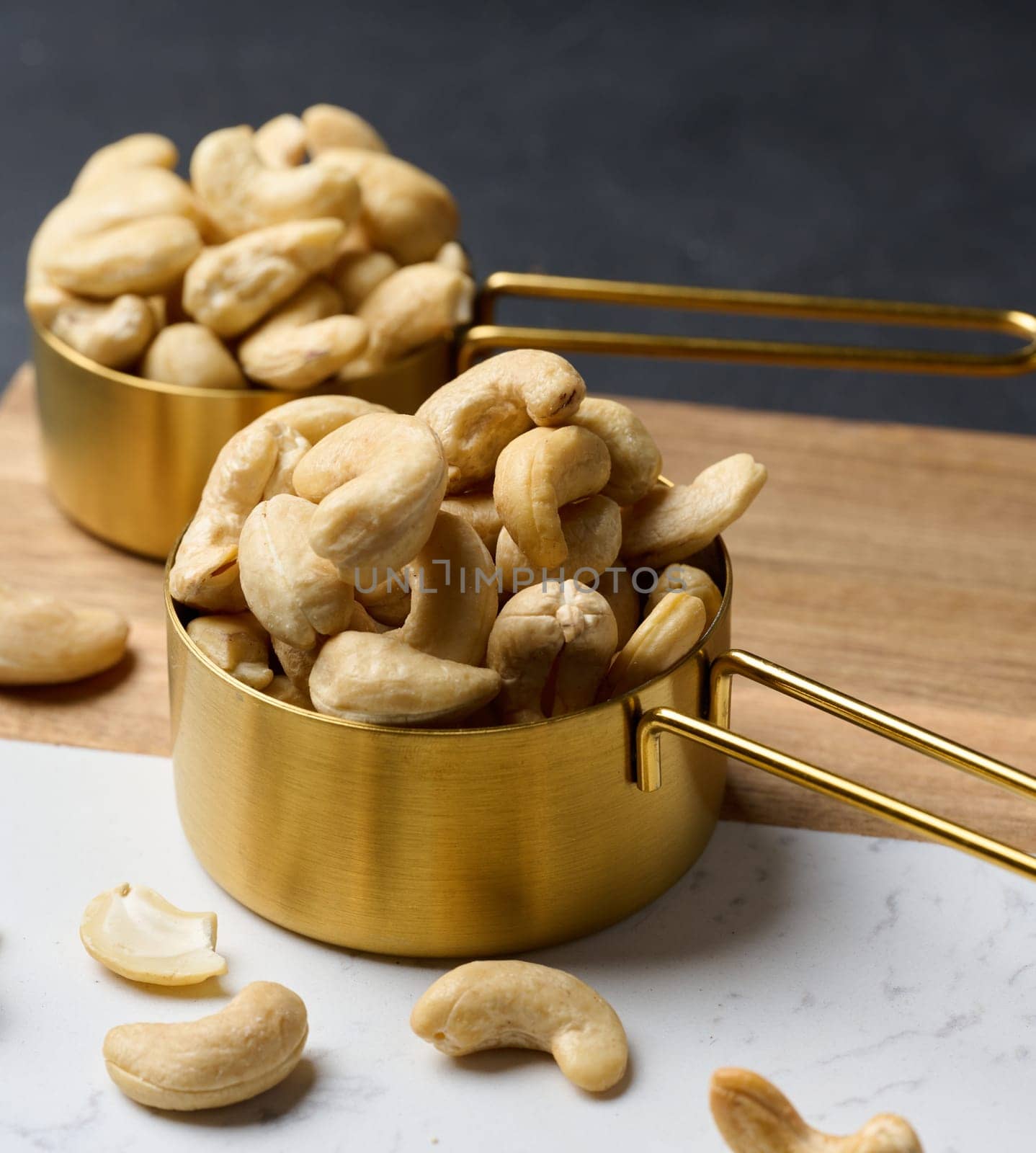 Cashews in a metal bowl on the table by ndanko