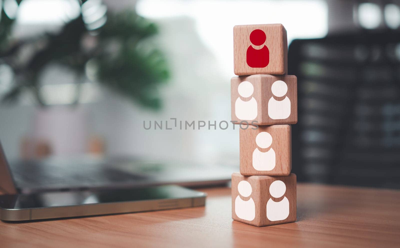 One wooden block has leadership and stands out with red manager icon placed on table as human resource management concept for leadership and teamwork.