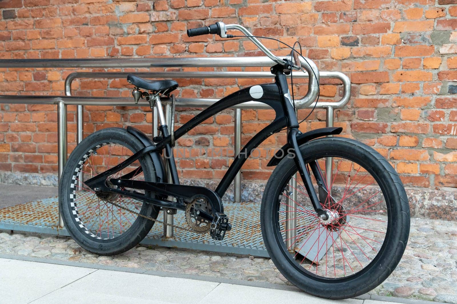 a cruiser-style bike is parked against the background of an old brick wall near a cafe or restaurant as a loft decoration and style