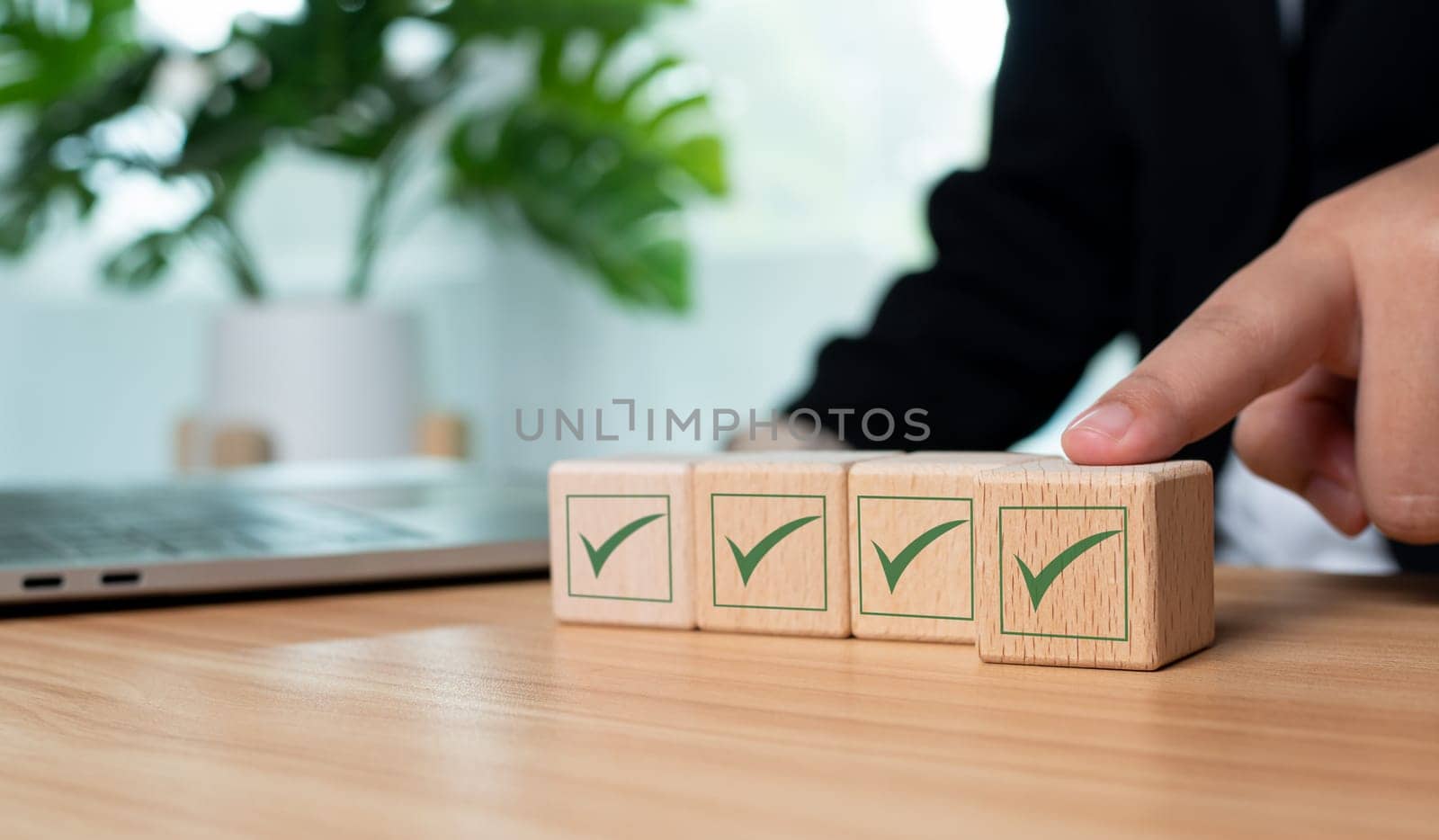 Businessman hand pushes the correct green symbol on a wooden cube for a business proposal and concept approval document. by Unimages2527