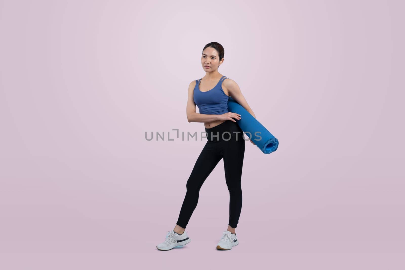 Young attractive asian woman portrait in sportswear with exercising mat. Healthy exercise and workout routine lifestyle concept. Studio shot isolated background. Vigorous