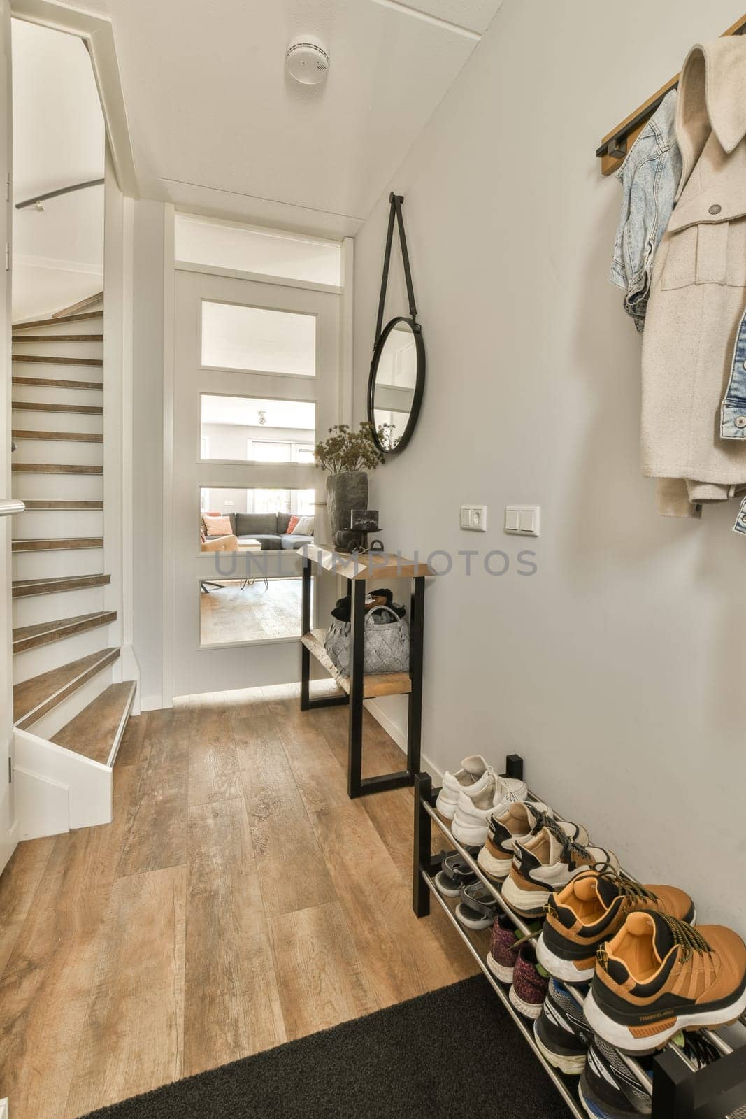 the inside of a house with some shoes hanging on the wall and stairs in the room is very well organized
