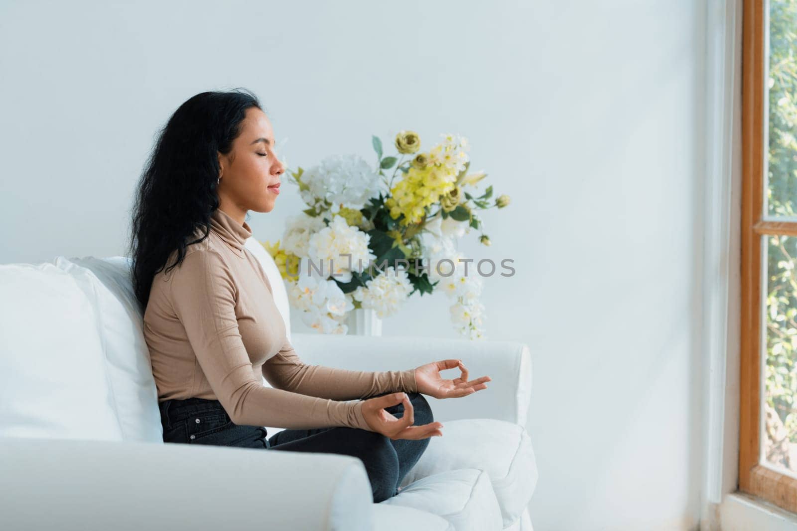 Young African American woman practice crucial mindful meditation at home living room for improving mental health strength and peaceful beautiful living