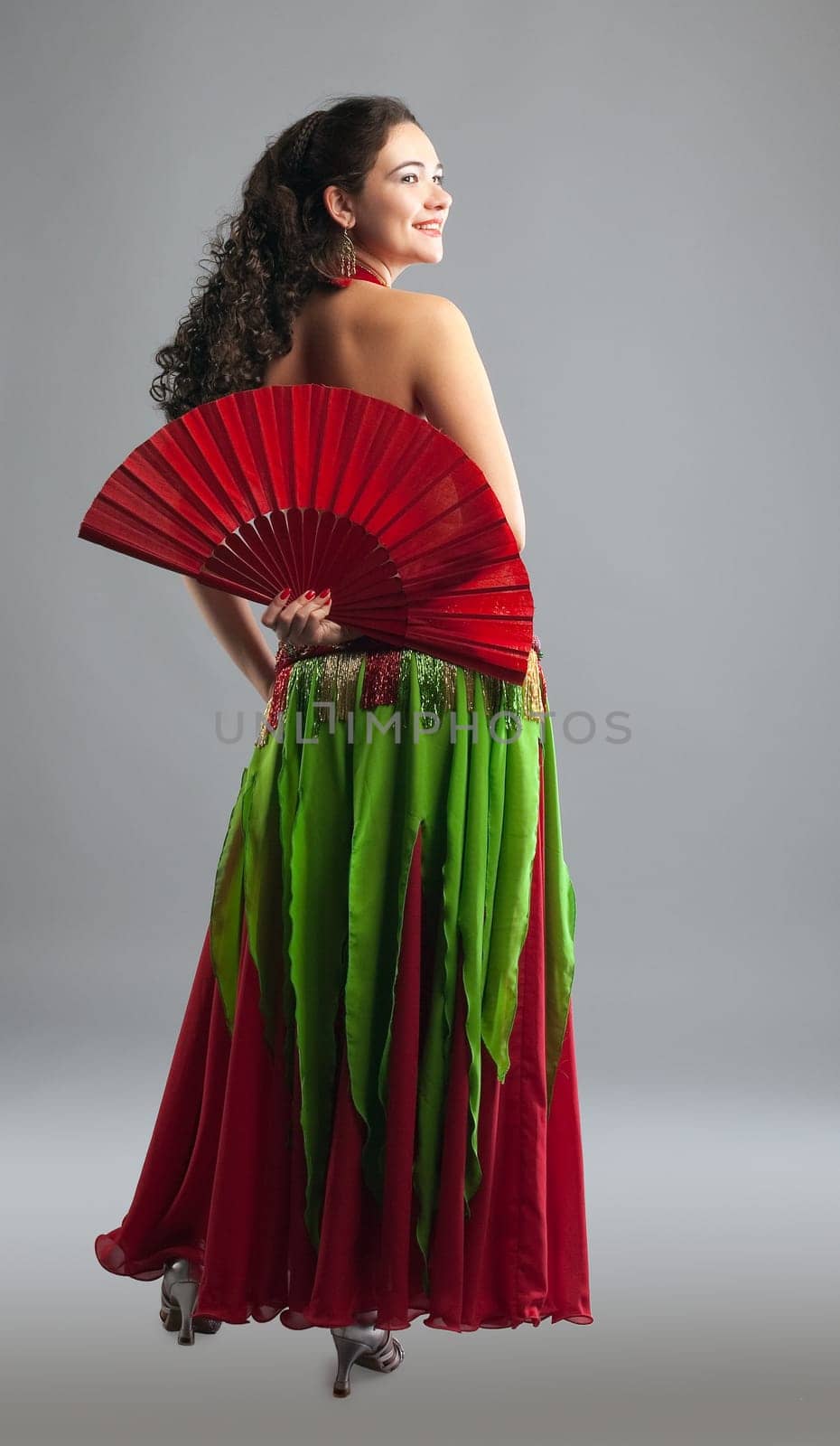 Young woman belly dance with fan in oriental arabic costume