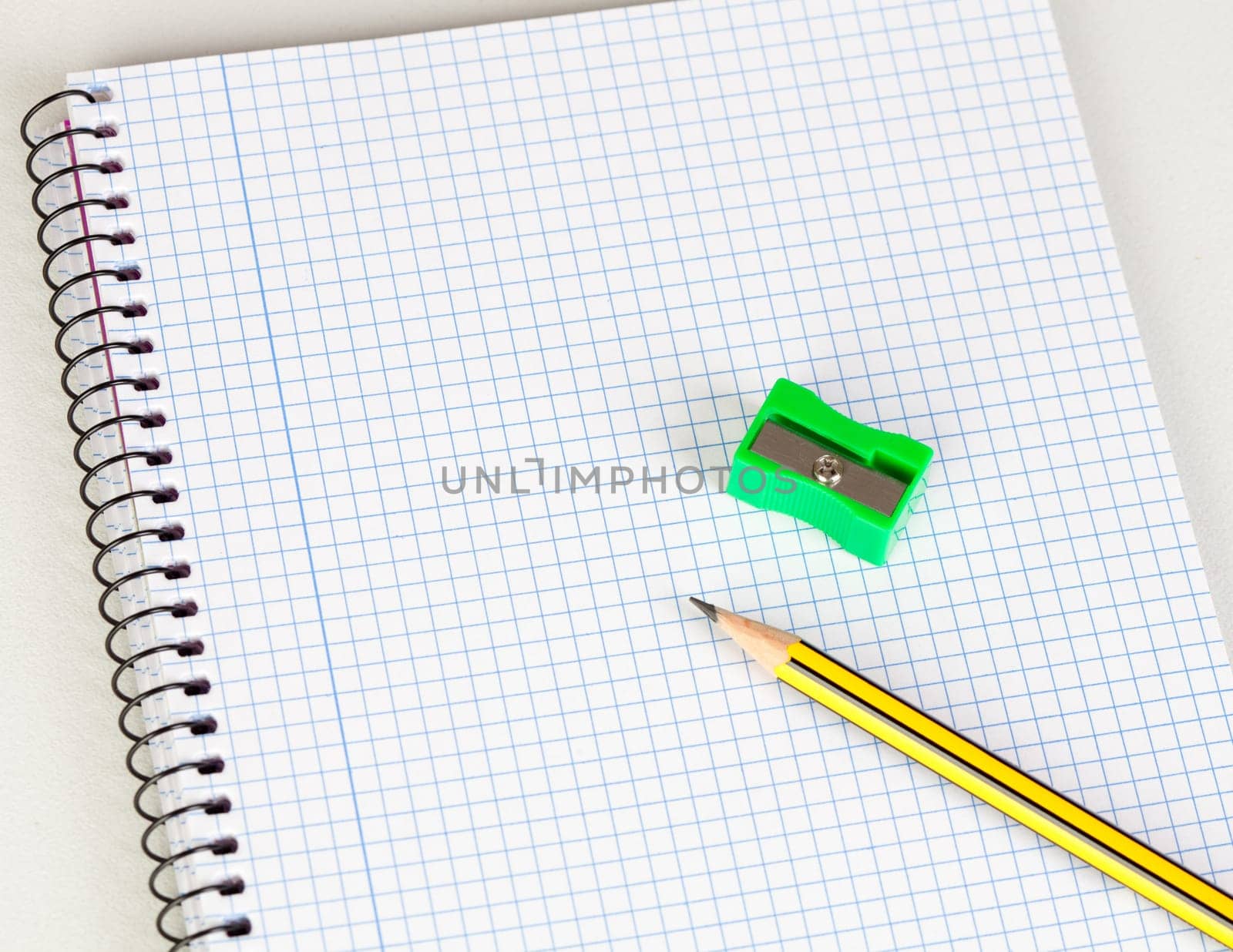 Sharp pencil and sharpener on a spiral notebook in blank