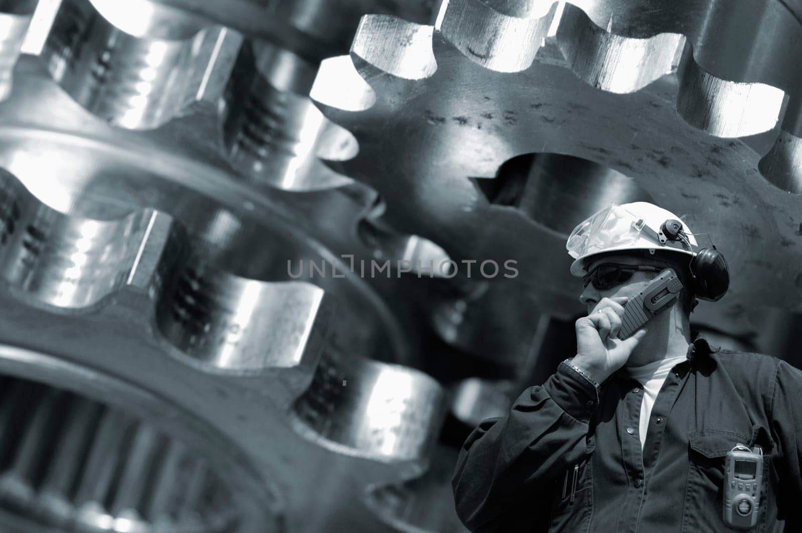 engineer, worker, large gear wheel machinery in background, symbolic with steel-works factory