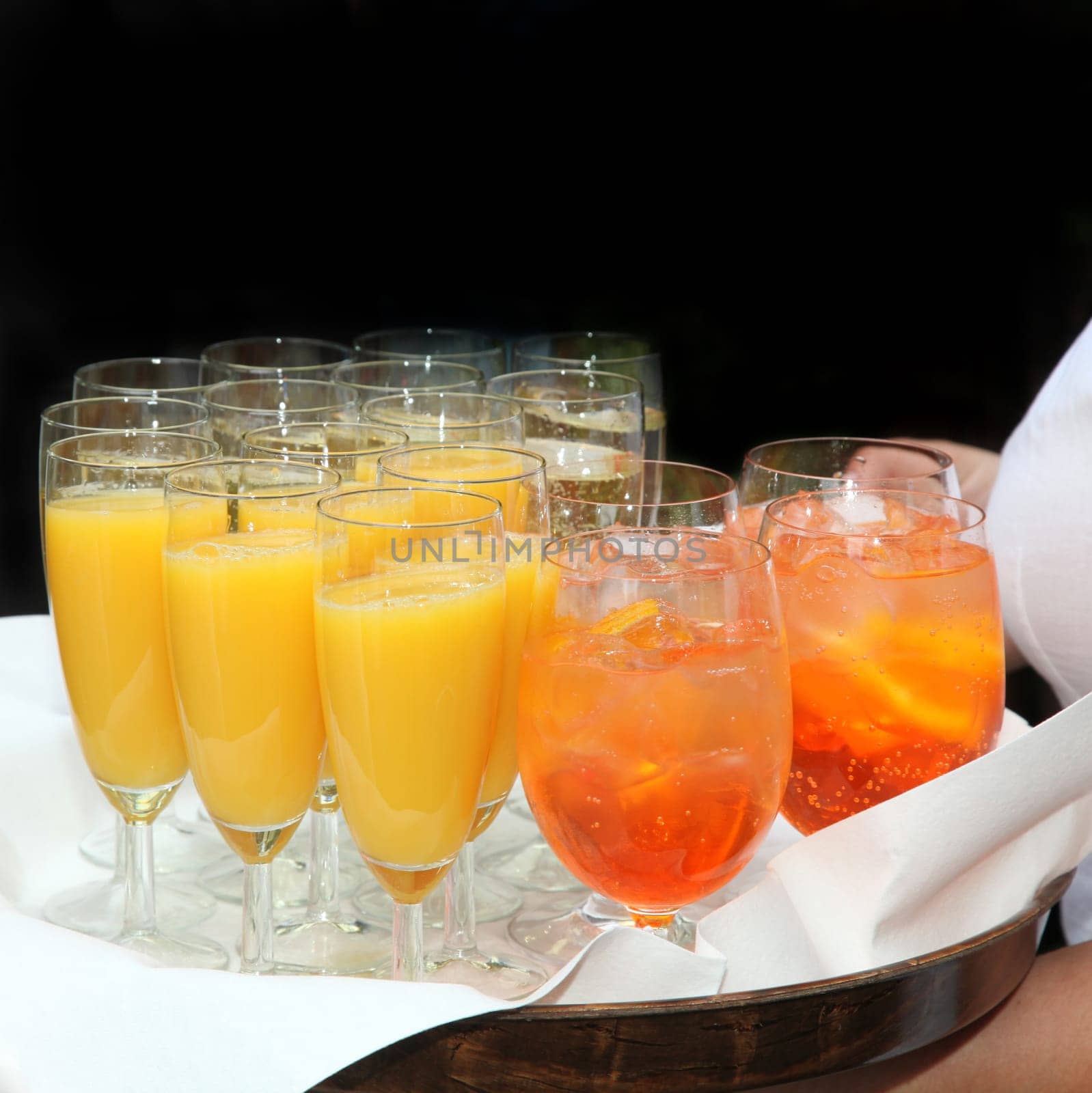 Sparkling wine,orange juice and cocktails served by the waiter - square