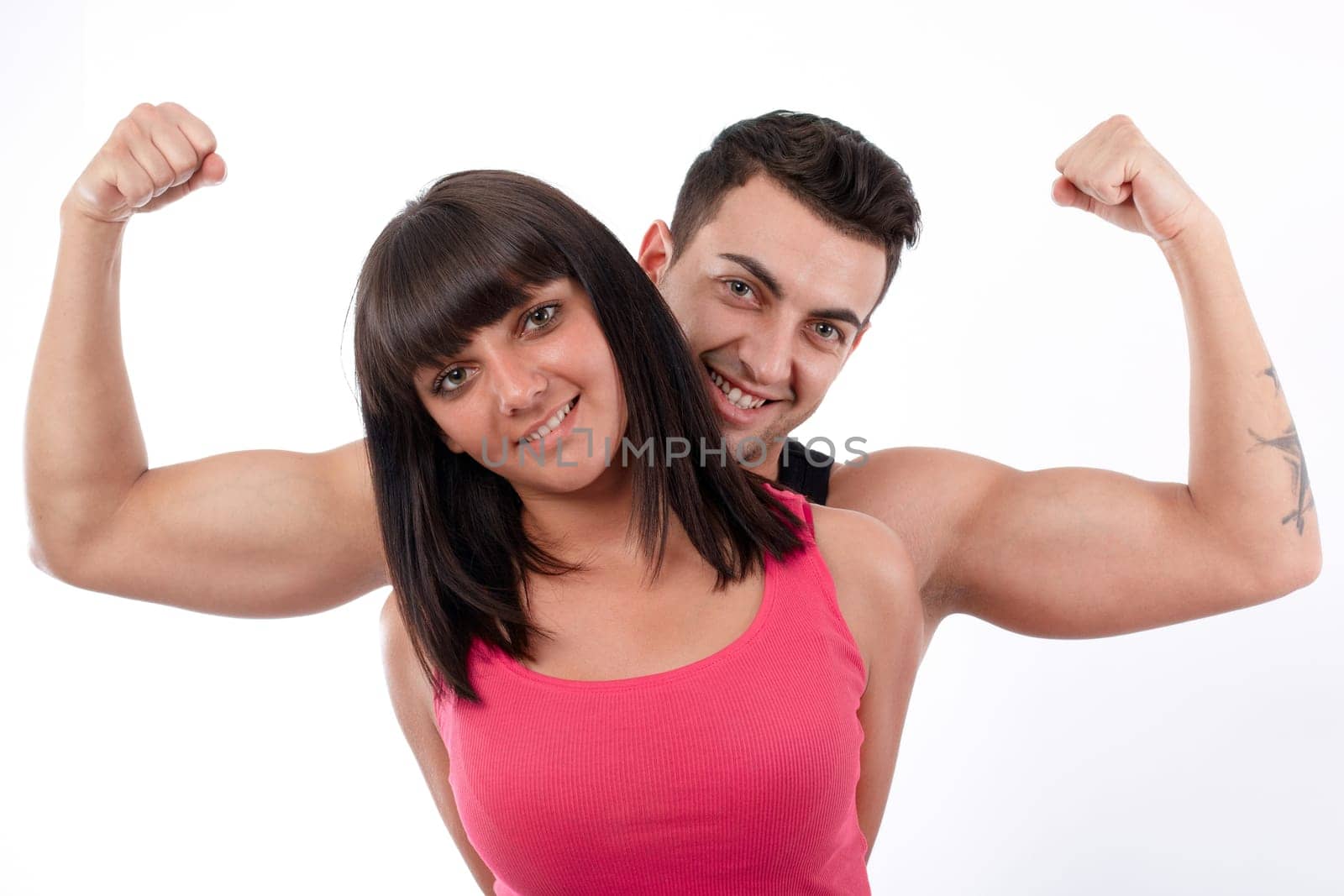Young men showing his biceps behind a young women