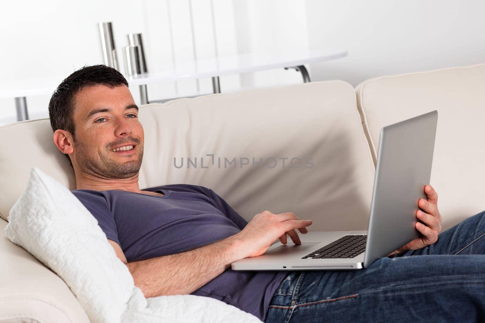 beautiful young man on sofa with computer