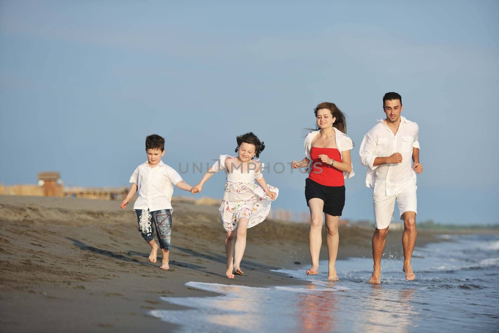 happy young family have fun and live healthy lifestyle on beach