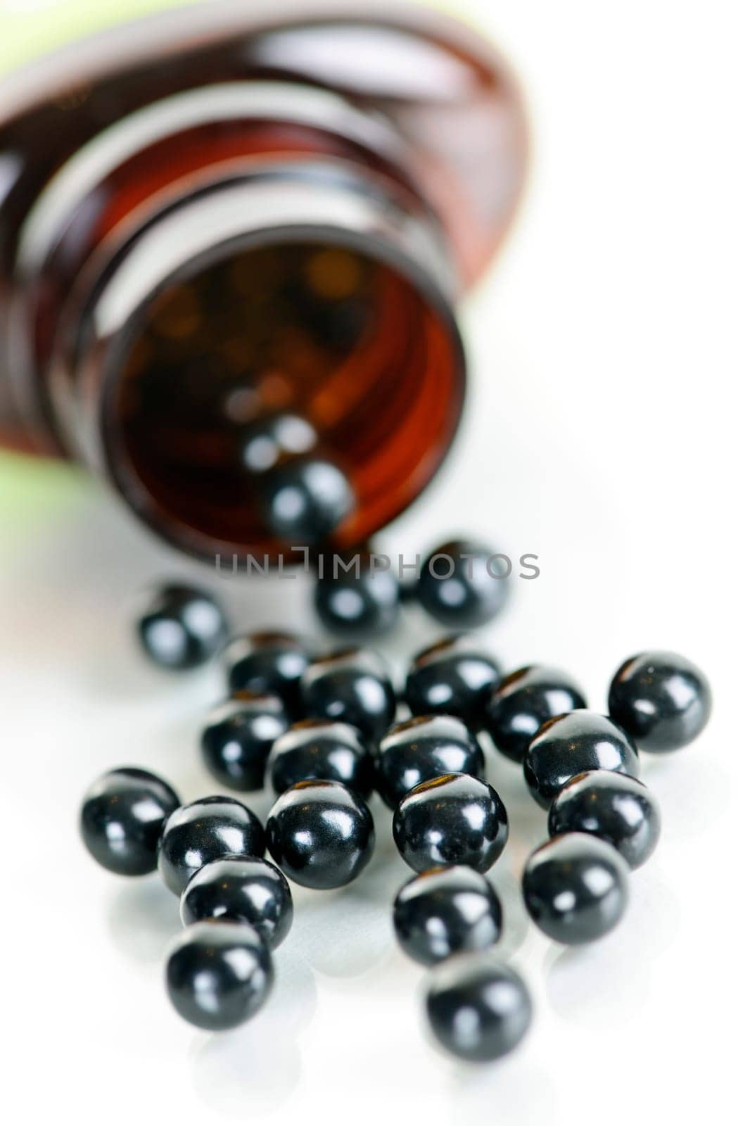 Traditional chinese herbal  medicine pills spilling from bottle on white background