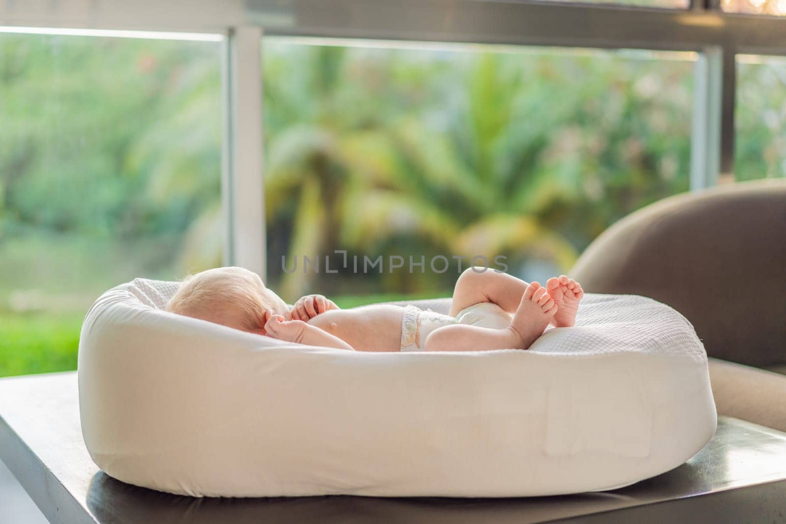 A newborn baby lies peacefully in their cozy sleep cocoon, gazing out of the window. A serene moment of curiosity and calm, symbolizing the early stages of life, peaceful reflection, and a connection with the outside world.