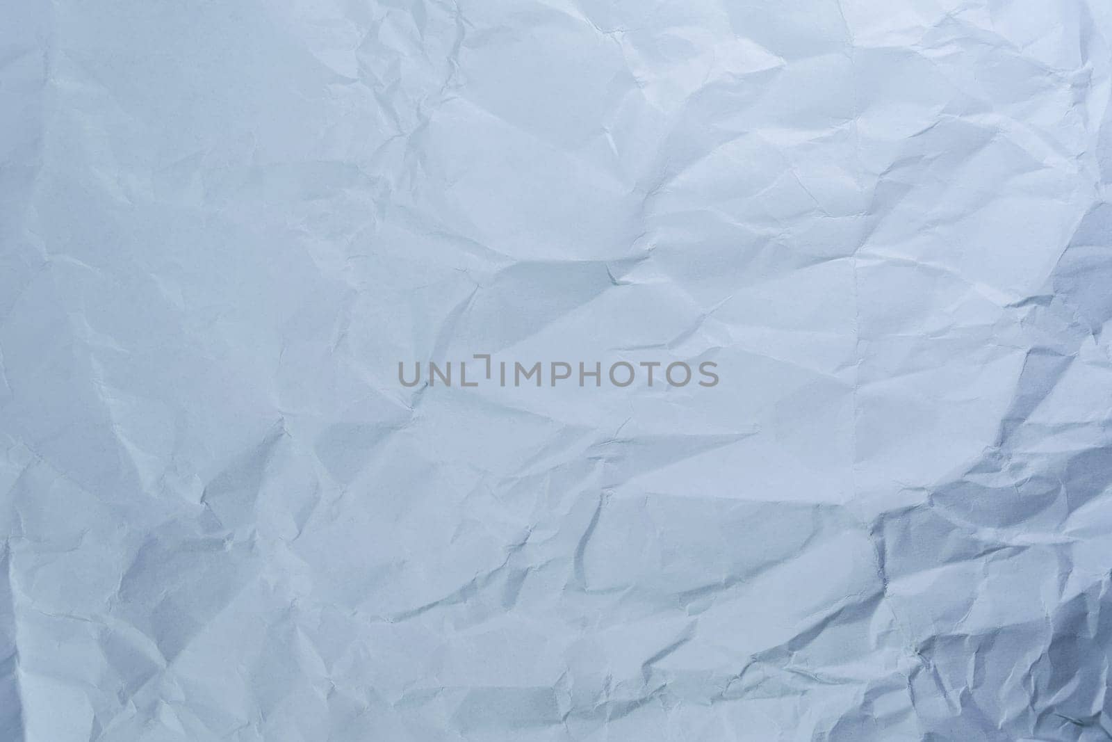 Crumpled white paper with detailed wrinkles and creases. Perfect for backgrounds, design templates, and texture overlays. Ideal for artistic and grunge-style projects