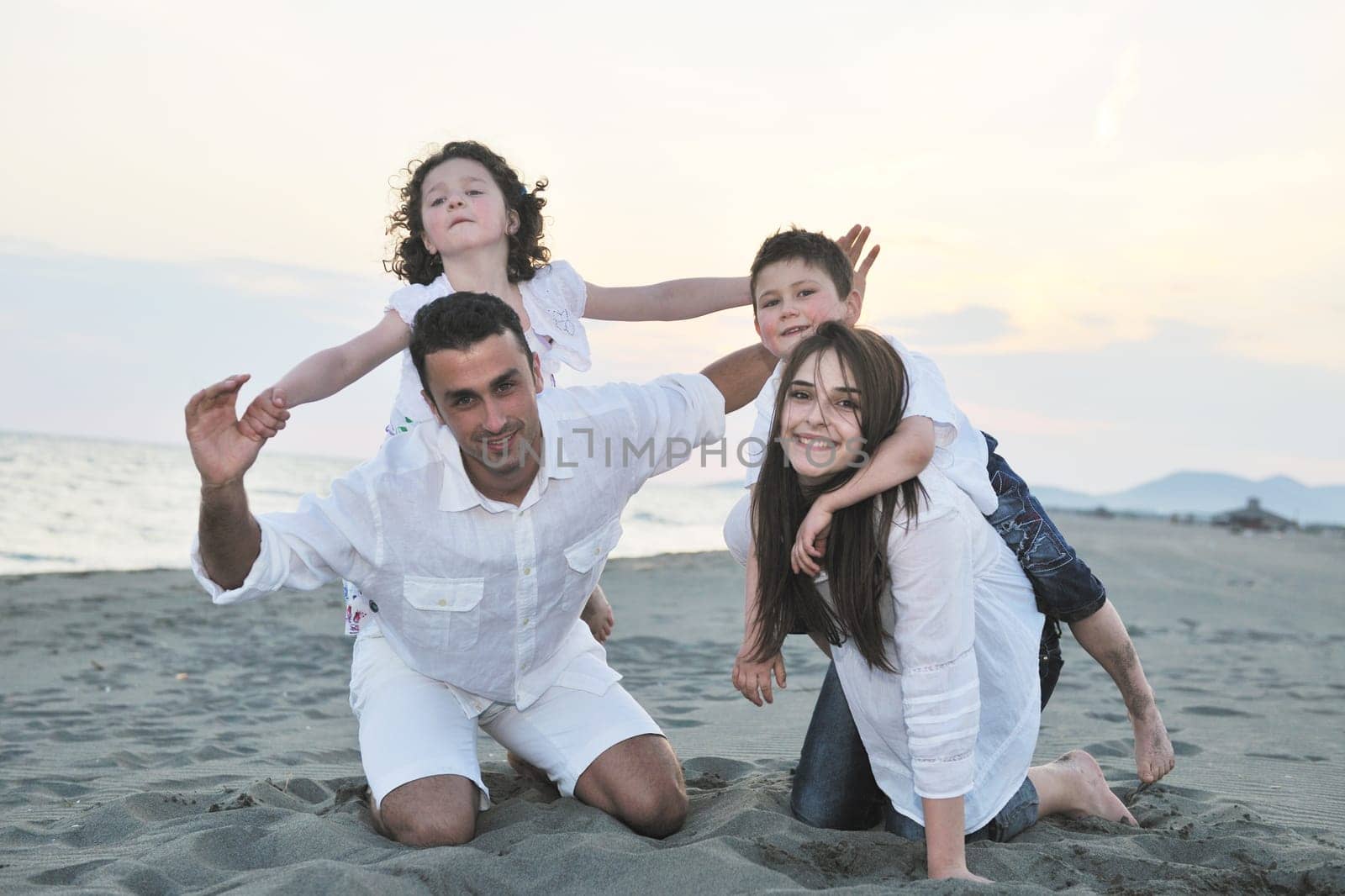 happy young family have fun and live healthy lifestyle on beach