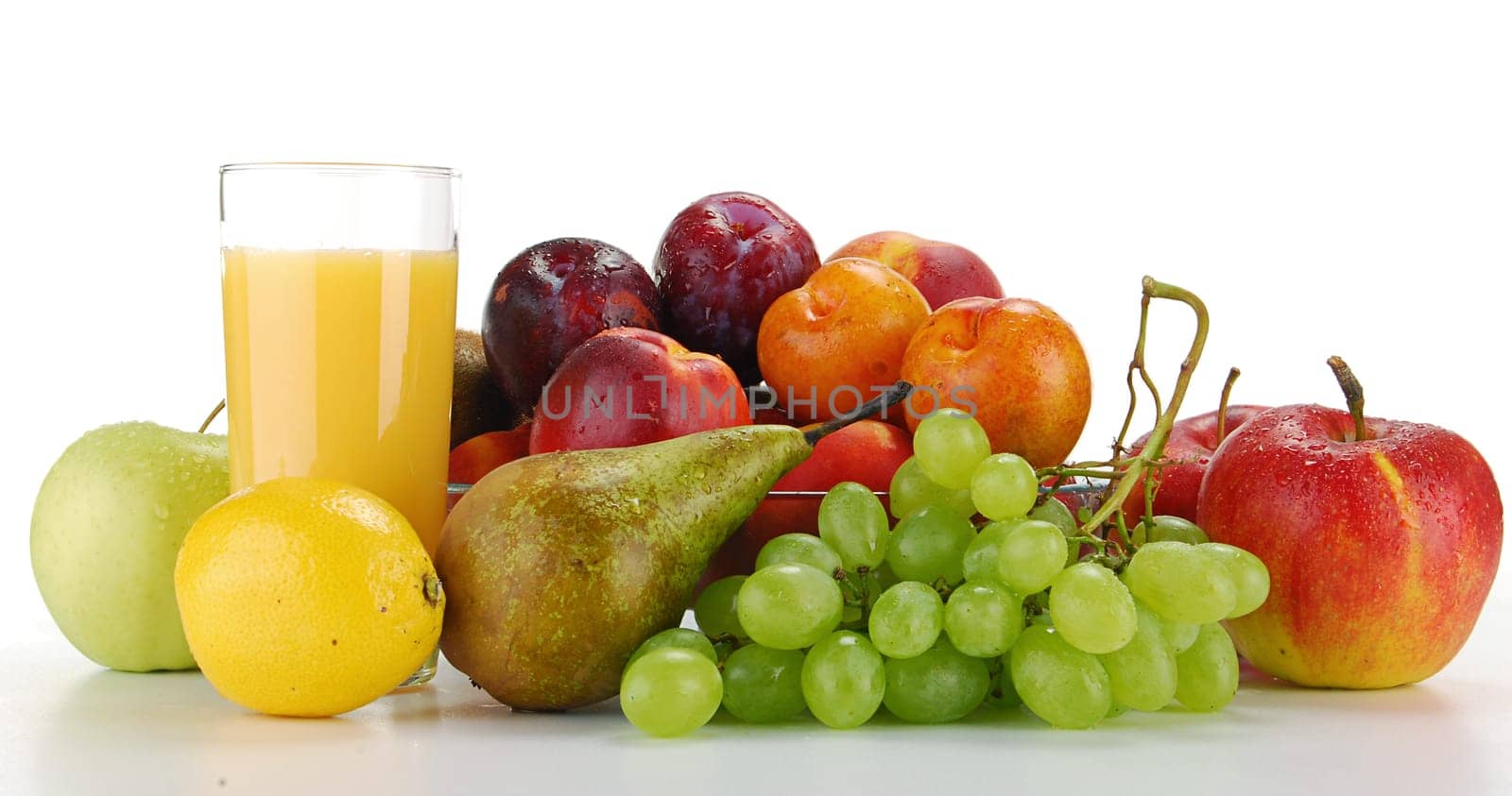 Composition with variety of fruits and glass of orange juice