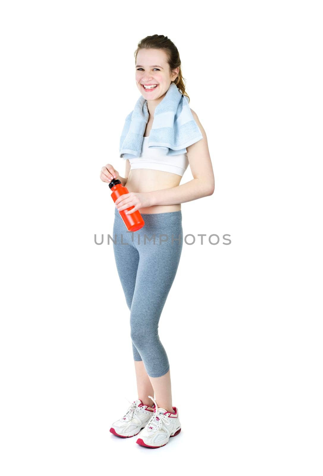 Happy fit young woman after workout with towel and water bottle