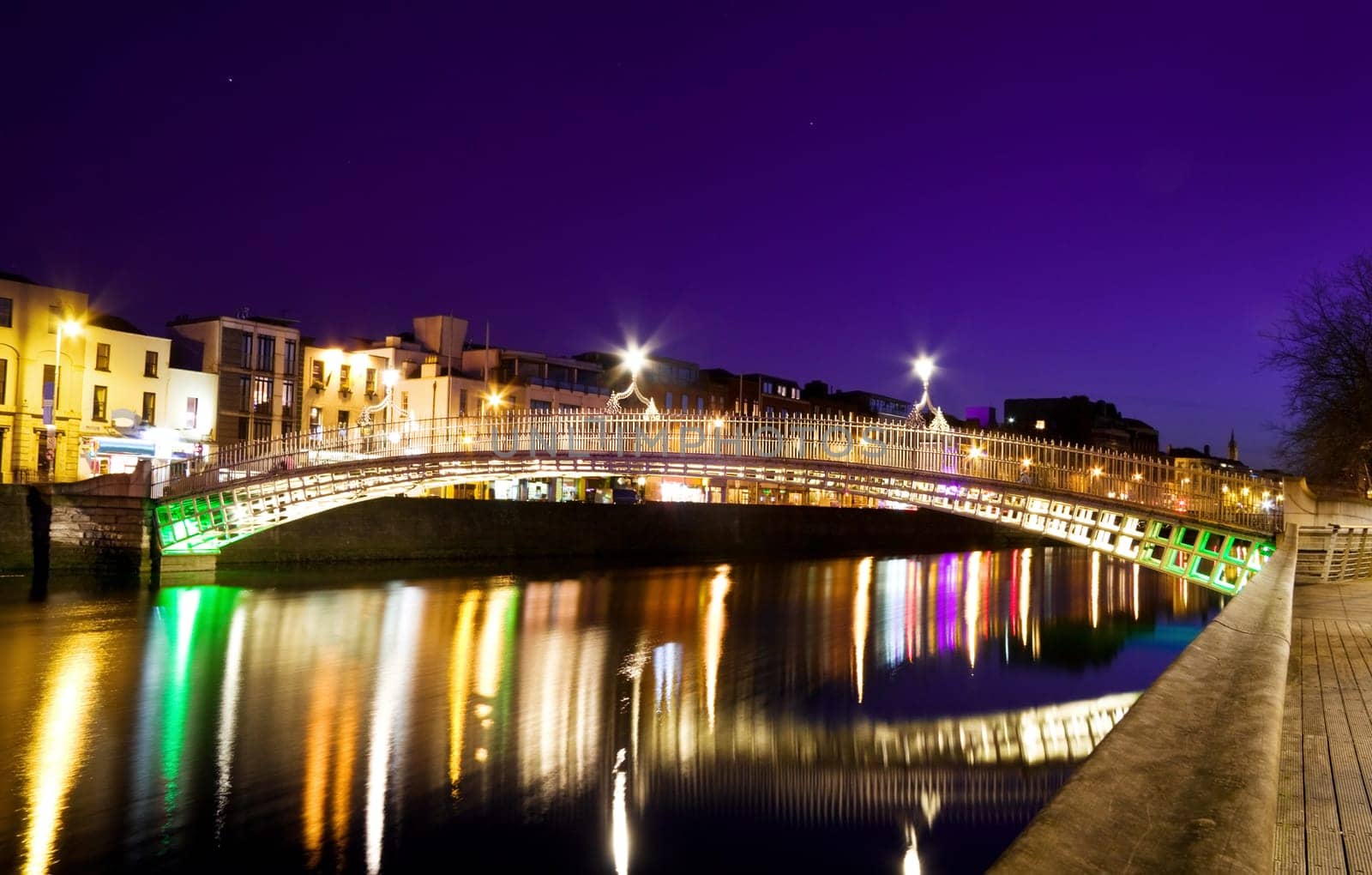 The Ha&#039 penny Bridge over the river Liffey was originally built in 1816 and is now a famous Dublin landmark much loved by tourists and locals alike. Shot was taken on a violet sky evening, long exposure, tripod used.