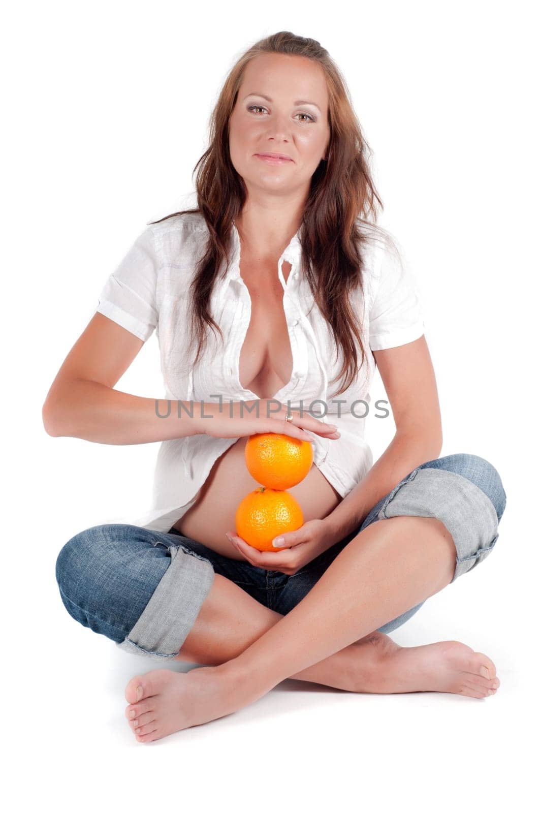 Beautiful pregnant with oranges woman in studio isolated on white