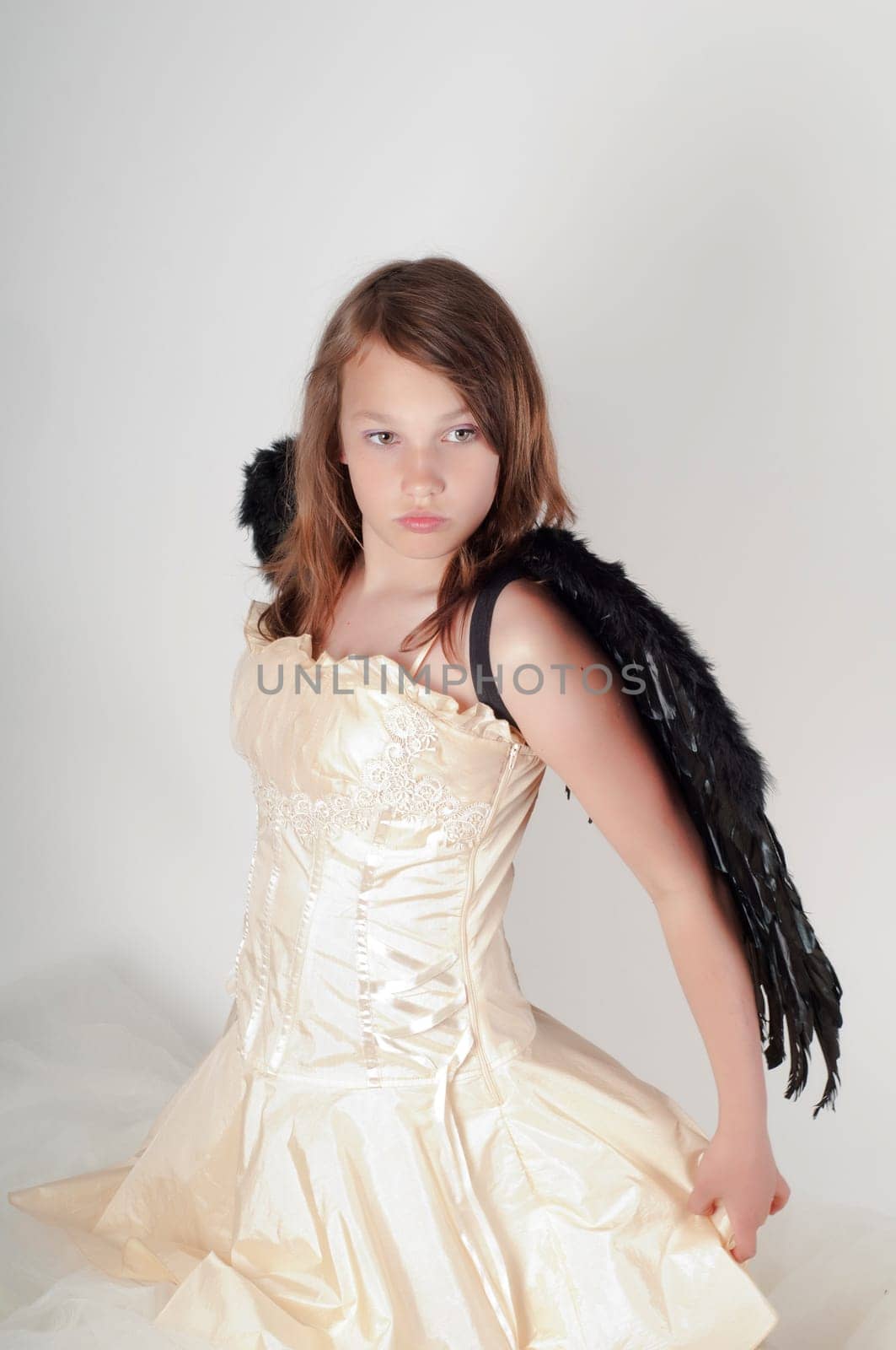 Teenager girl with black wings in studio