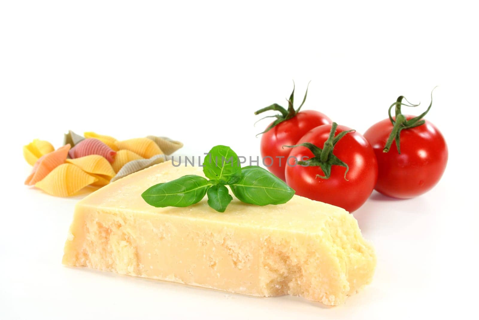 a piece of parmesan with basil and tomato