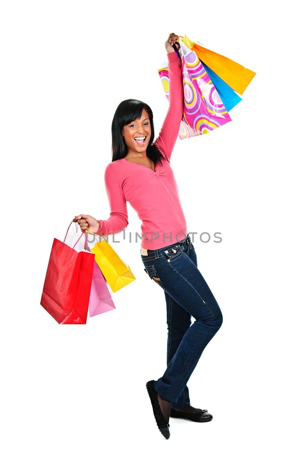 Young excited smiling black woman holding shopping bags